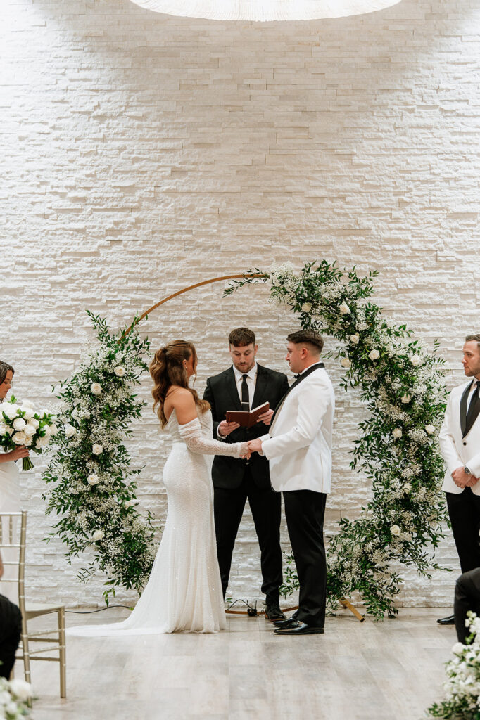 Bride and groom holding hands during their wedding ceremony