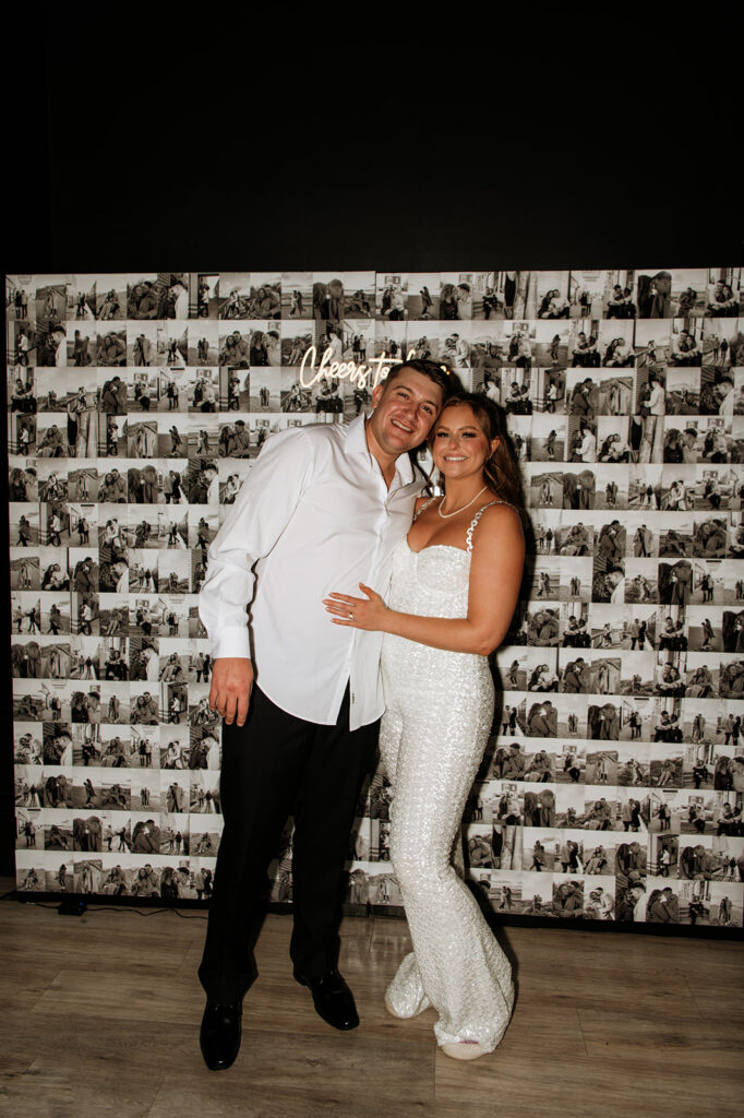 Bride and groom posing in front of their photo backdrop