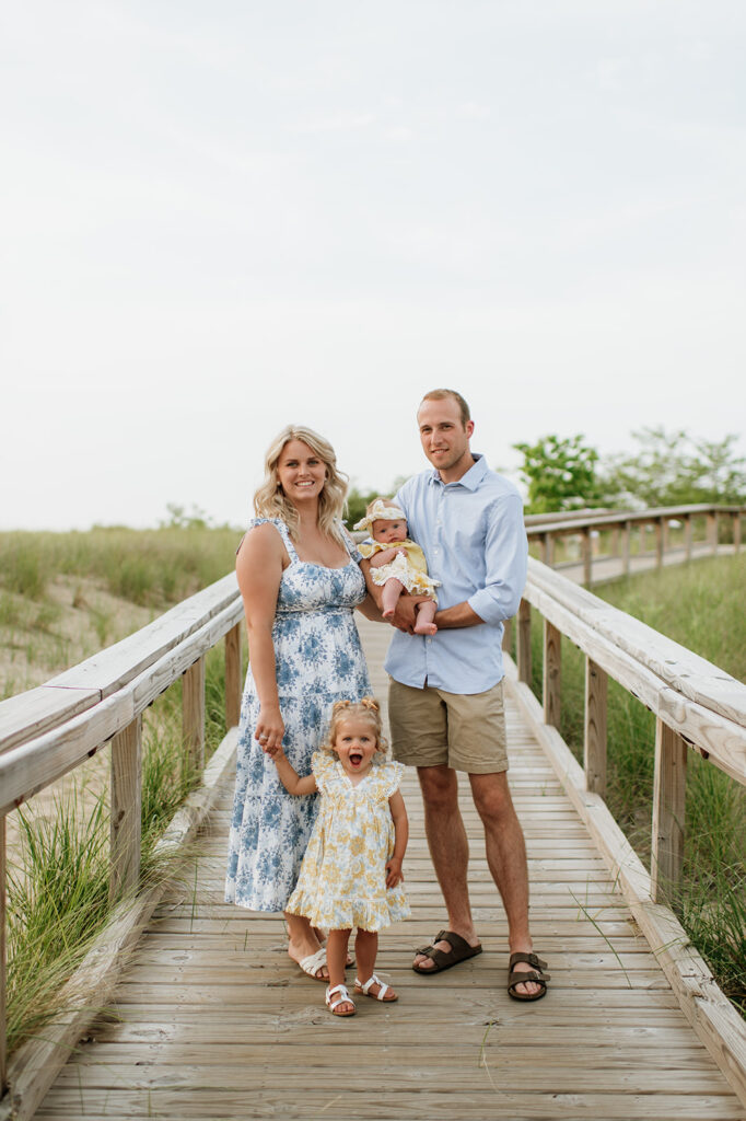 Family of four posing on a boardwalk at New Buffalo Beach in Michigan