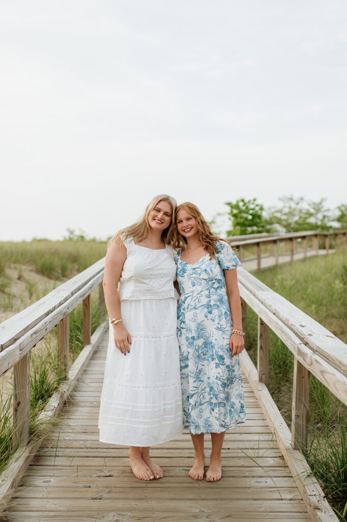 Sisters posing together on a boardwalk in New Buffalo Beach, Michigan
