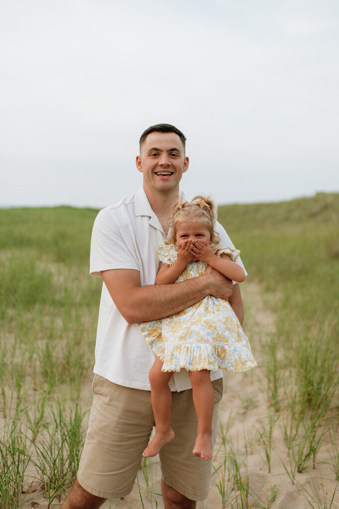 Uncle holding his niece on the beach