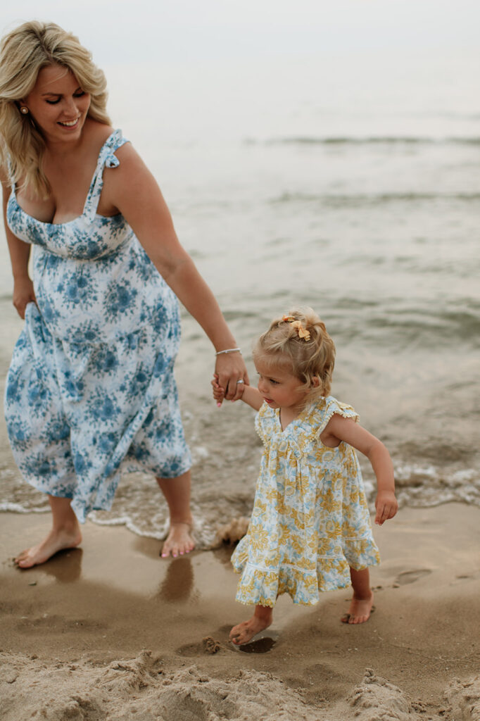 Mother and daughter walking the Lake Michigan shoreline and holding hands