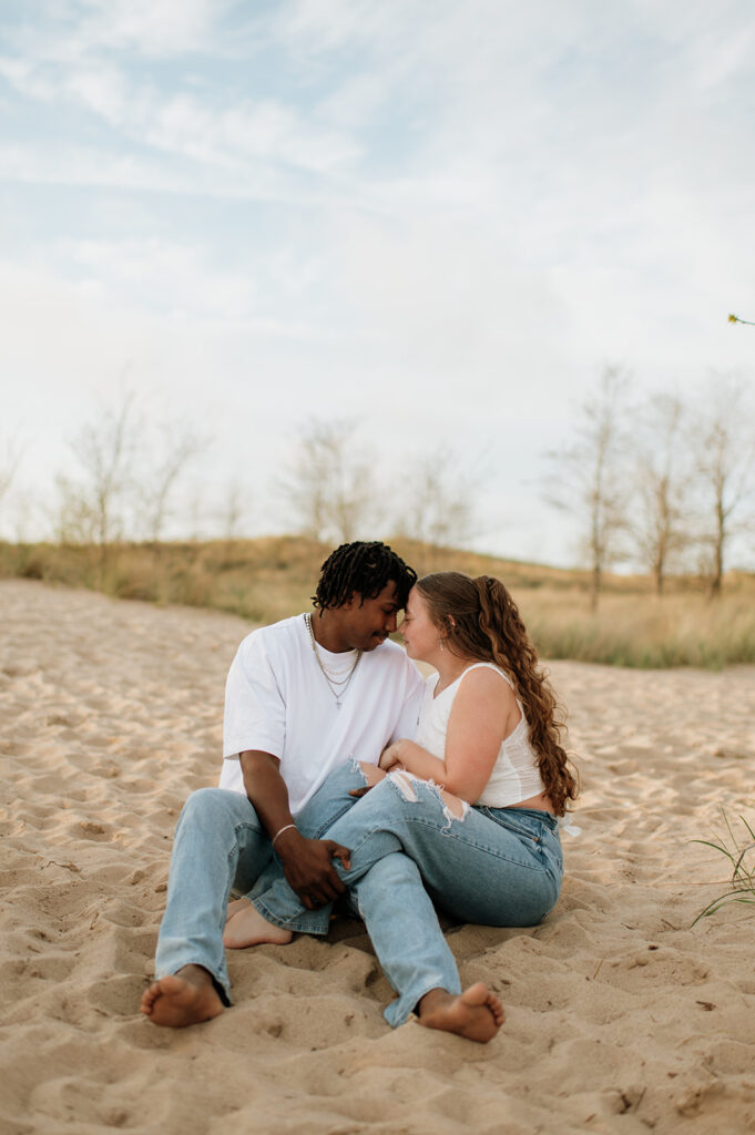 Couple sitting on the sand on New Buffalo beach in Southwest Michigan