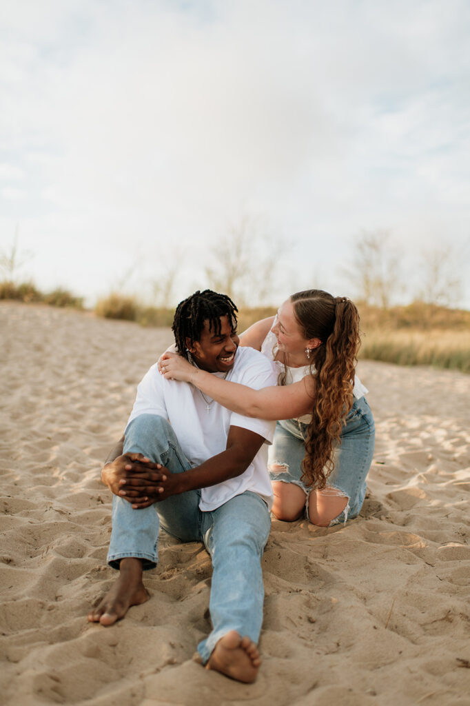 Couple posing for their Southwest Michigan engagement photos at New Buffalo beach
