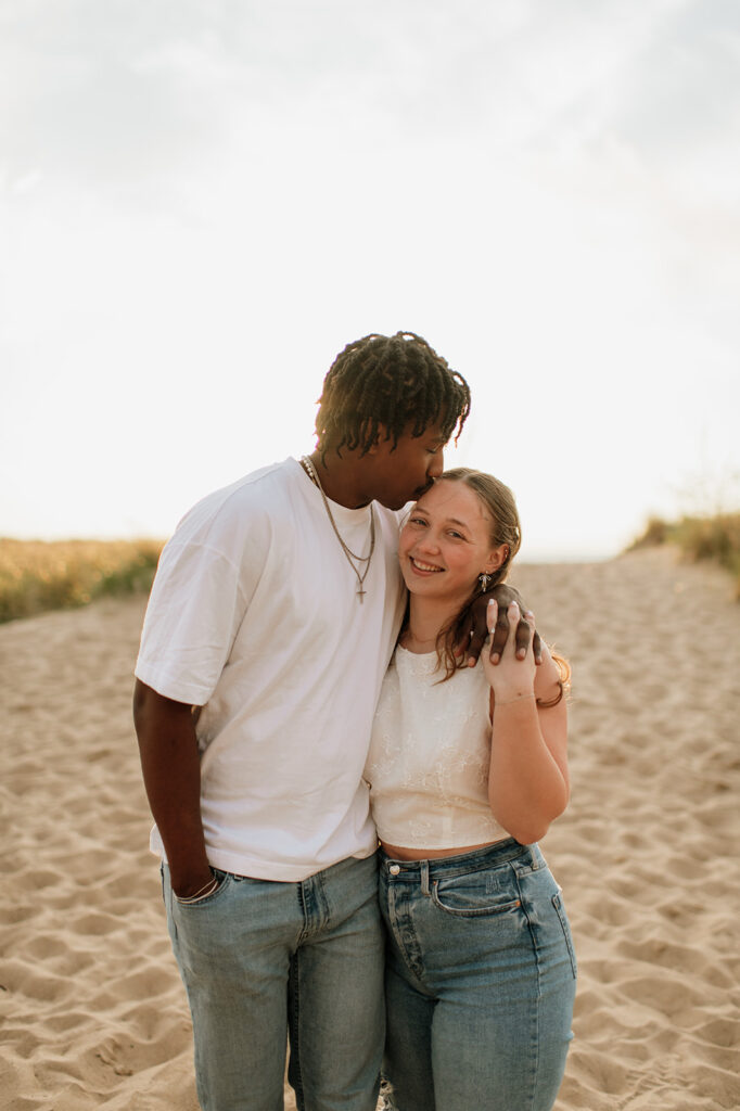 Couple walking along the beach in Southwest Michigan for their outdoor engagement photos at sunset