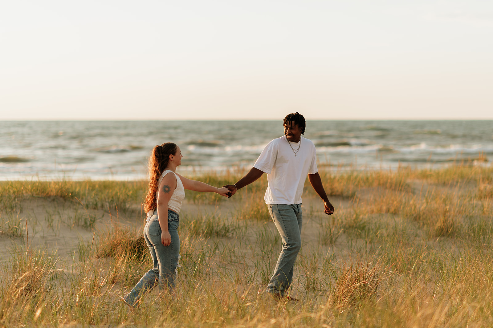 Couple holding hands and walking along the beach together