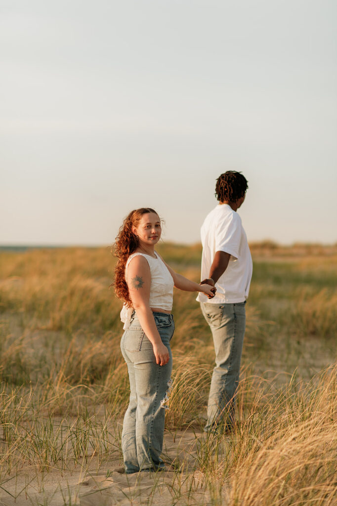 Woman looking back at the camera as they walk along the beach