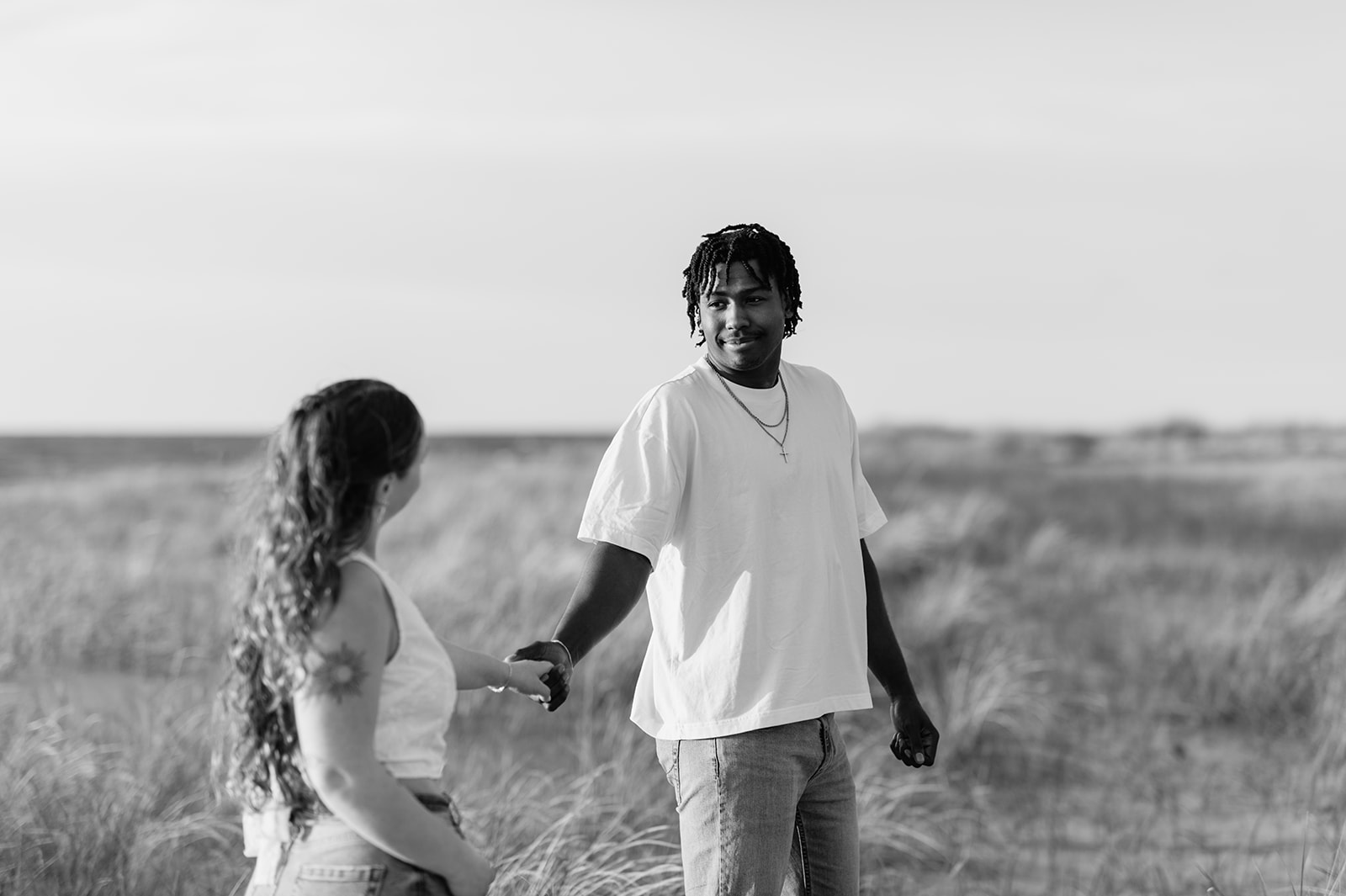 Black and white photo of a couple posing on the beach