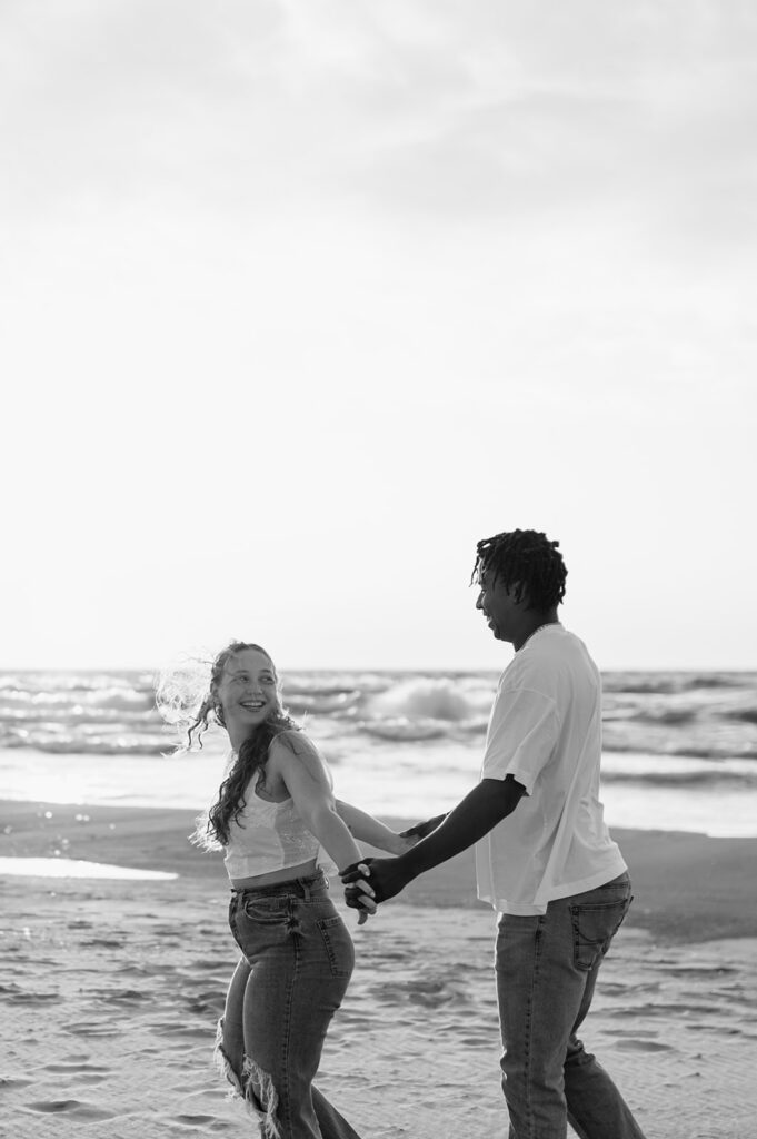 Black and white photo of a couple walking along the Lake Michigan shoreline