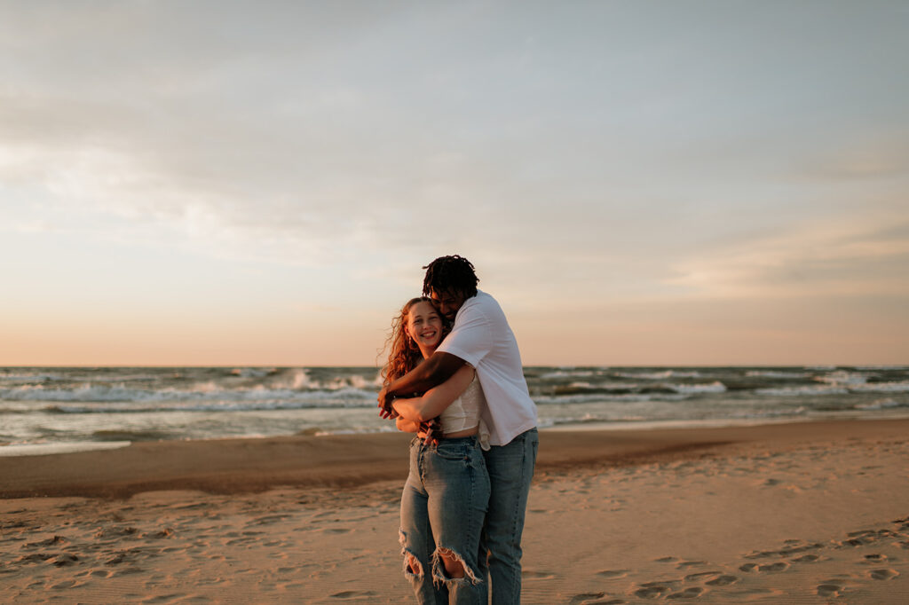 Couple hugging on the beach at sunset