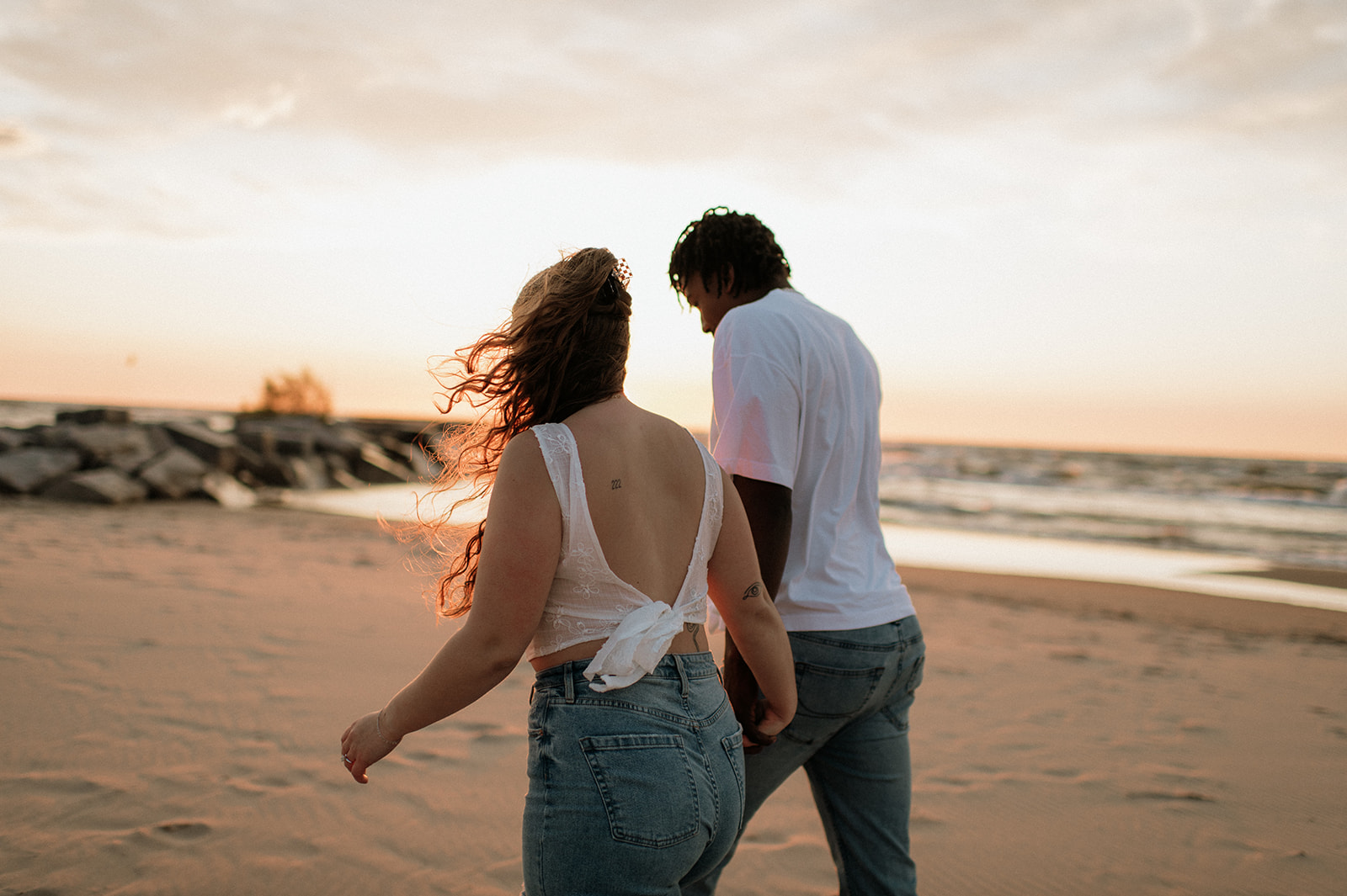 Couple walking along the beach at sunset in New Buffalo, Michigan