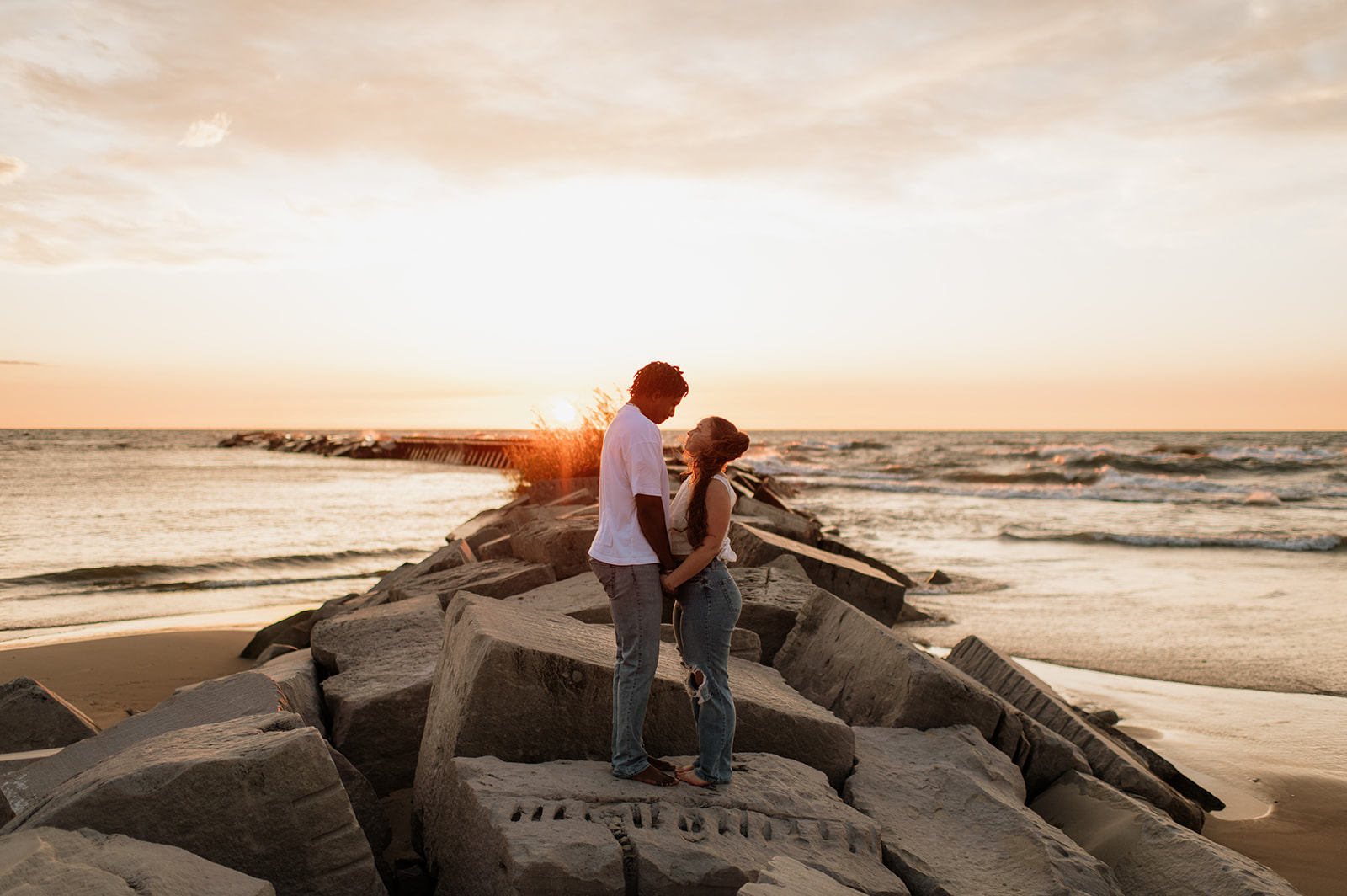 Couple holding hands during sunset at New Buffalo Beach in Southwest Michigan
