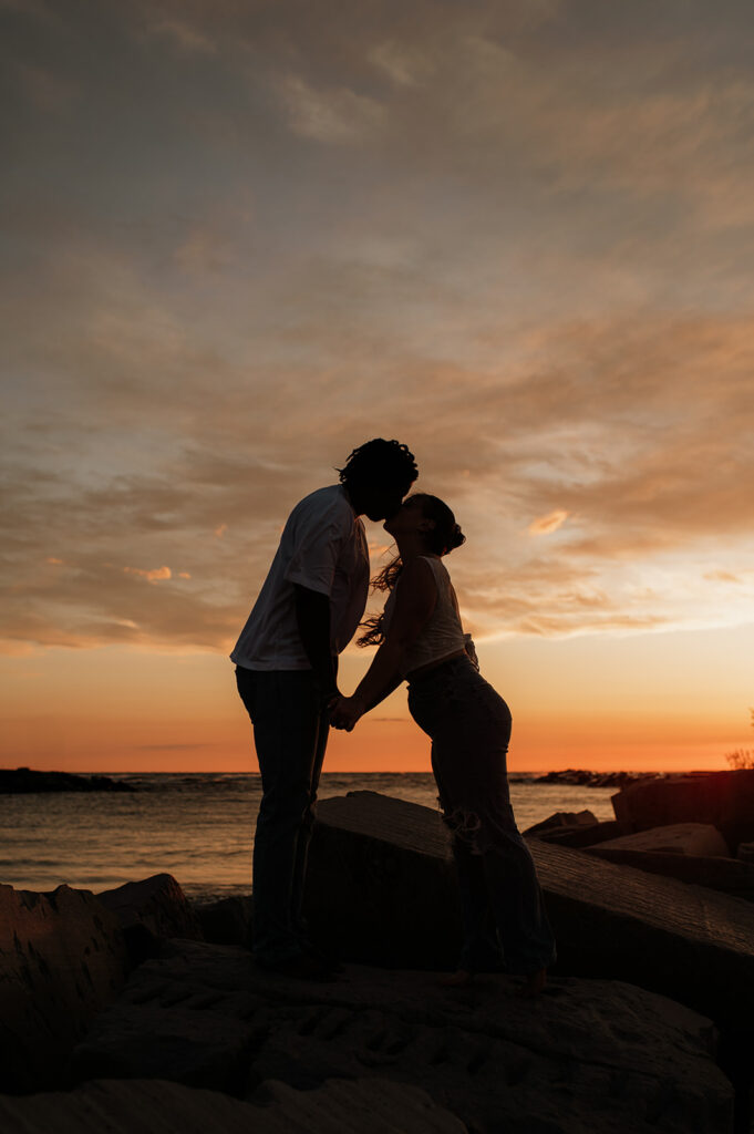 Couple kissing at sunset on New Buffalo beach in Michigan for their Southwest Michigan engagement photos