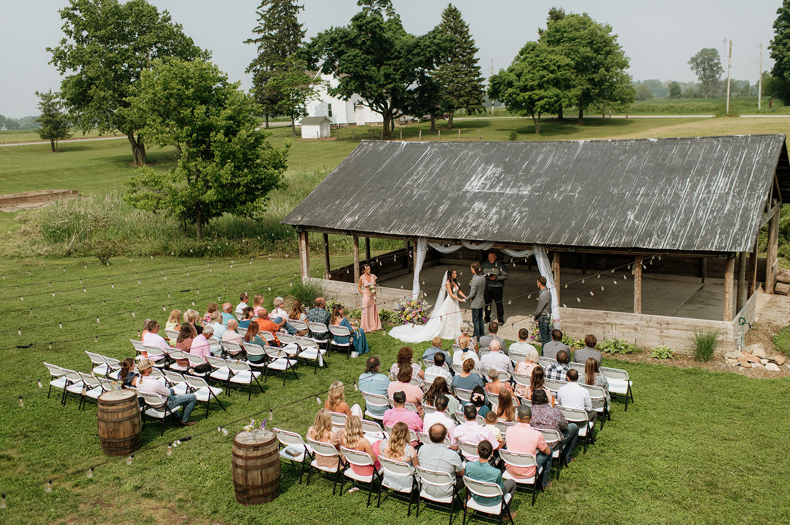 Aerial view of the outdoor wedding ceremony at 5C Farms with guests seated in rows and the couple at the altar.