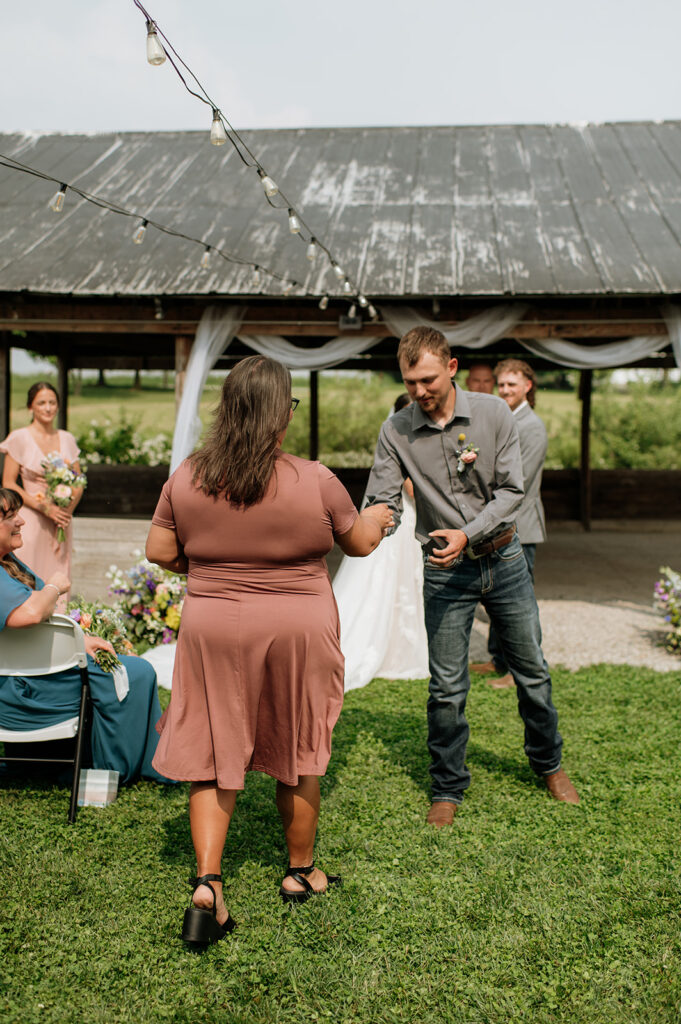 Wedding guest bringing up the rings to the bride and groom