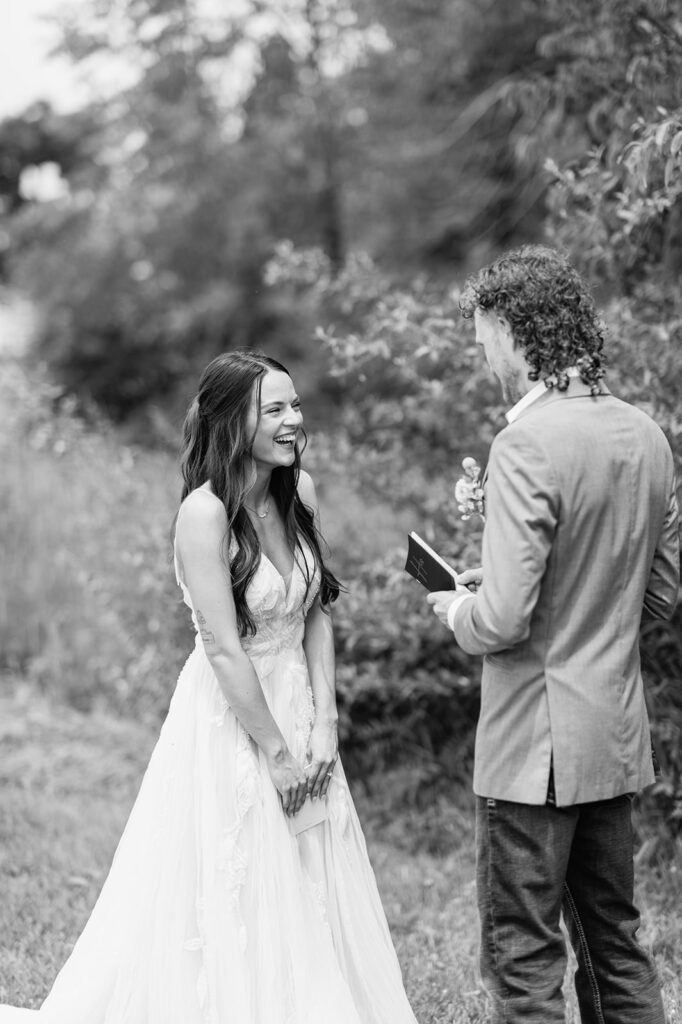 Black and white photo of a groom reading his vows to his bride