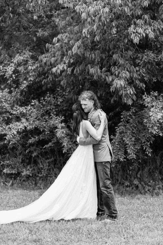 Black and white photo of a bride and groom hugging after sharing their vows