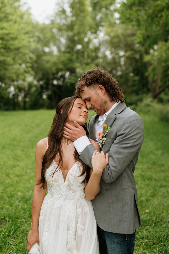 Bride and groom caressing each other during their outdoor wedding portraits