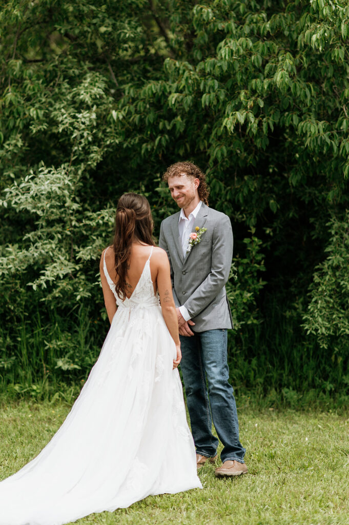 Groom turning around and smiling at his bride-to-be for their first look