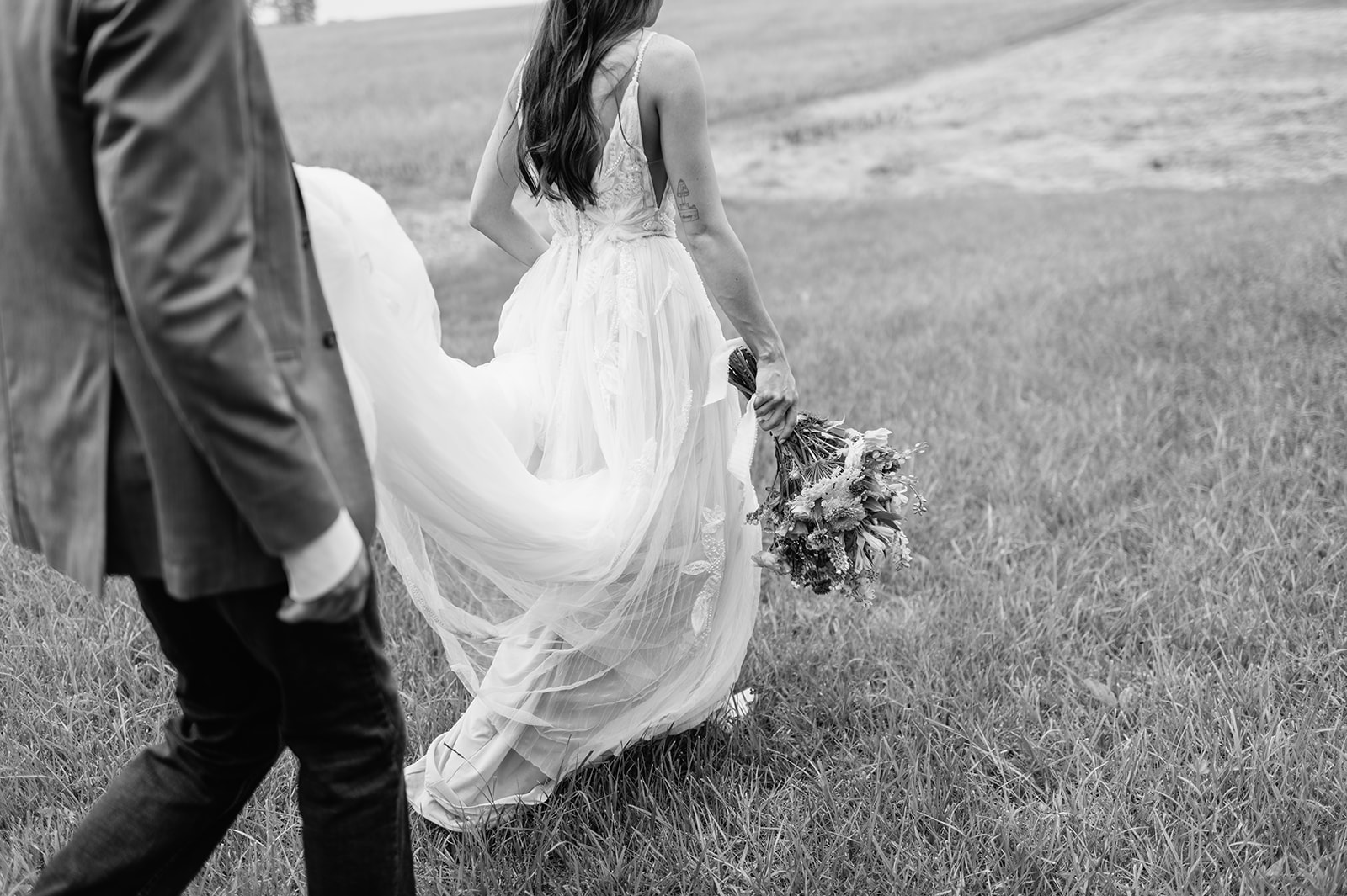 Black and white close up shot of a bride and groom walking to their wedding venue