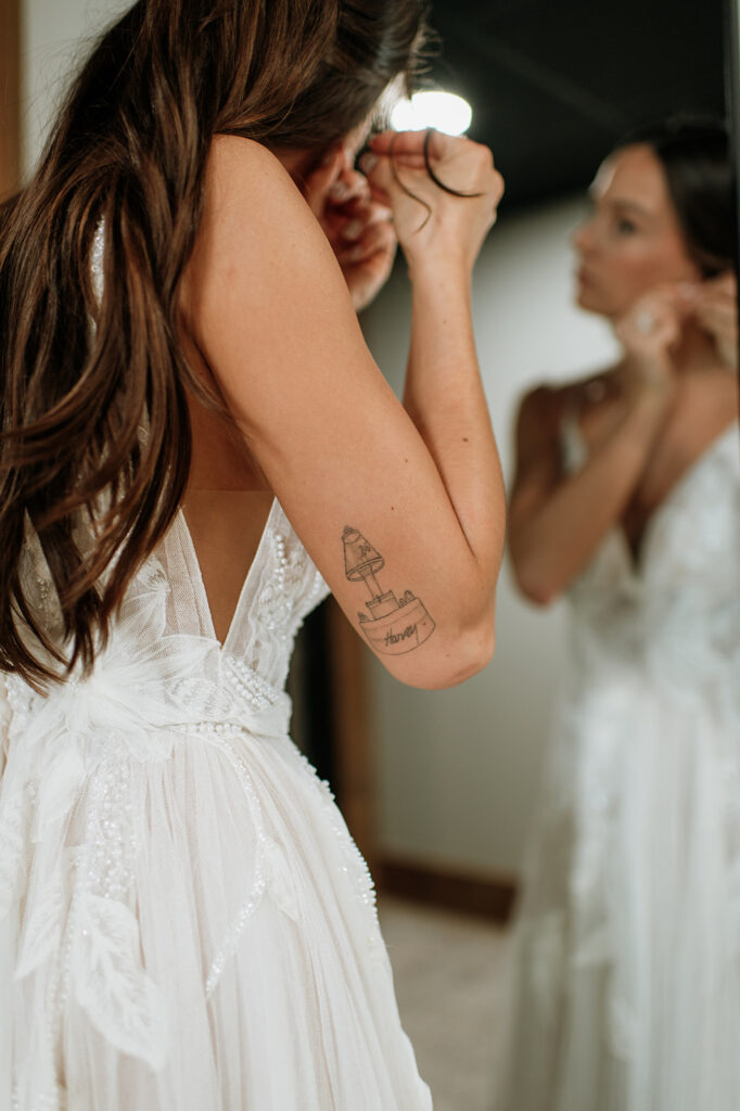 Bride putting her earrings in for her wedding