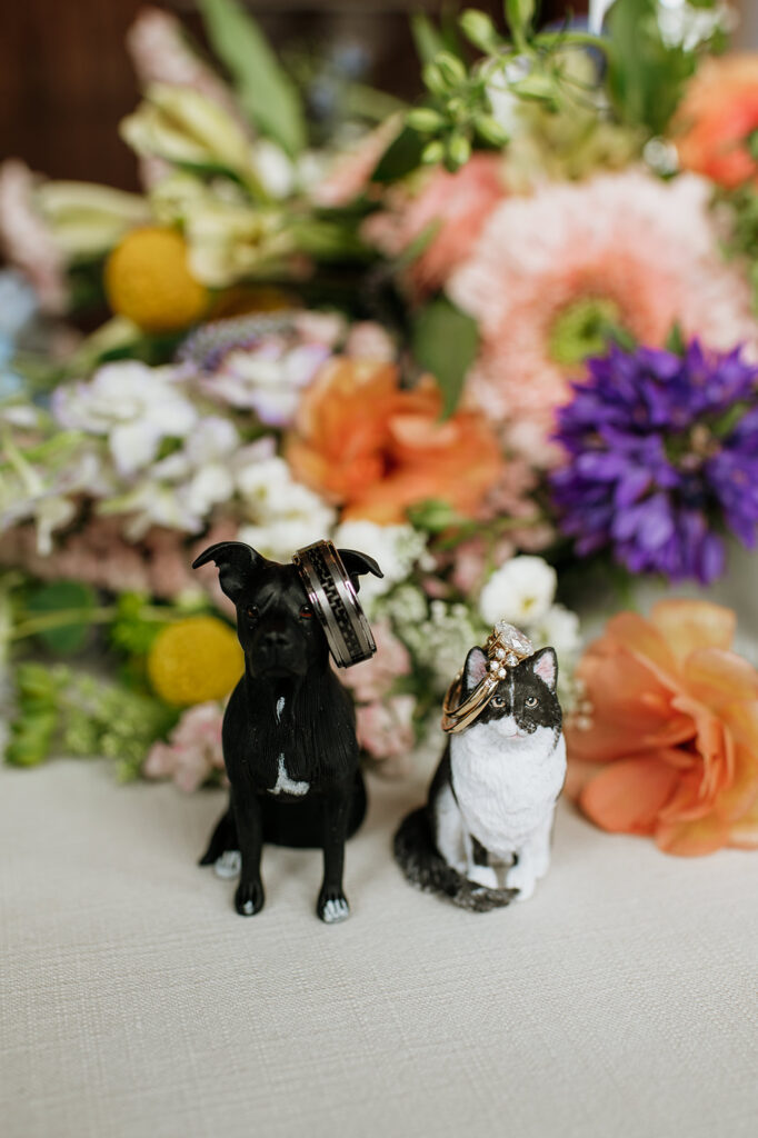 Bride and grooms wedding rings on their custom dog and cat figurines 
