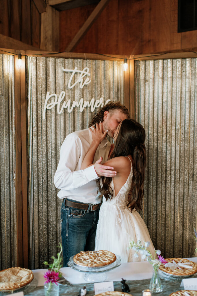 Bride and groom kissing after theie pie cutting