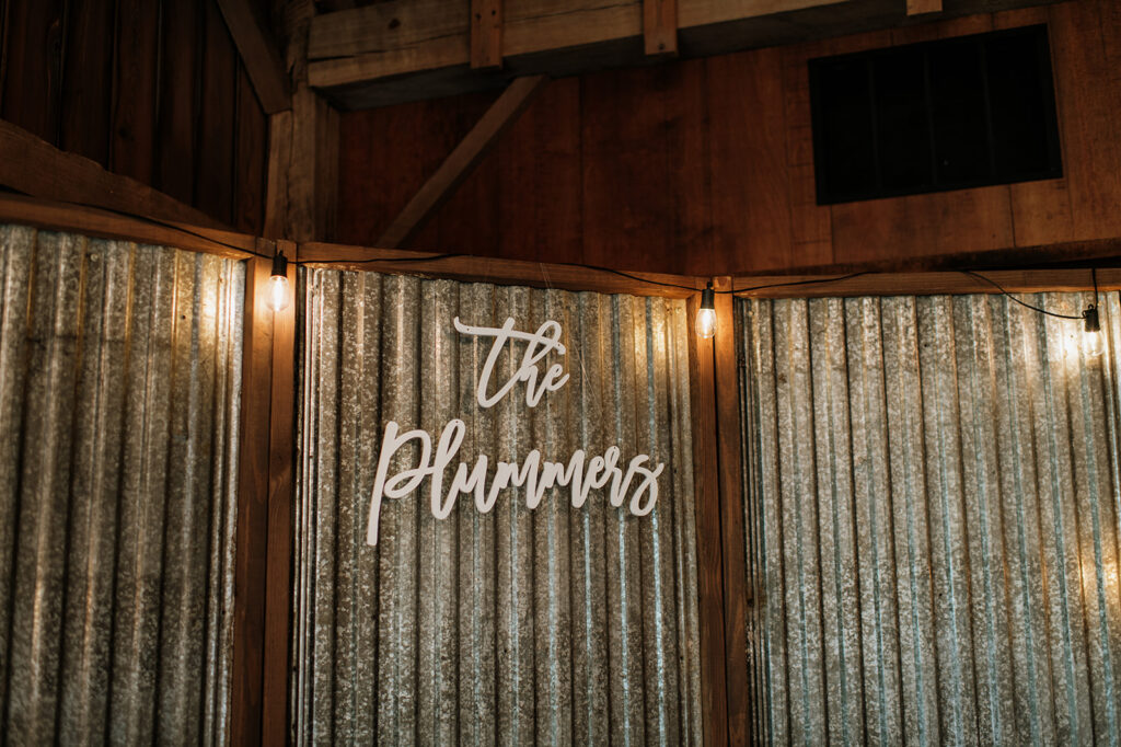 White cutout sign that reads “The Plummers.”