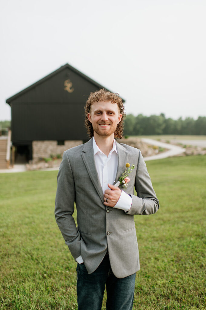 Groom posing outside of 5C Farms - Premier Indiana barn wedding venue
