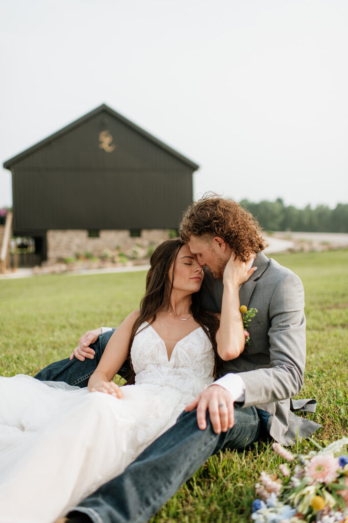 Bride and groom sitting together outside of 5C Farms - Premier Indiana barn wedding venue