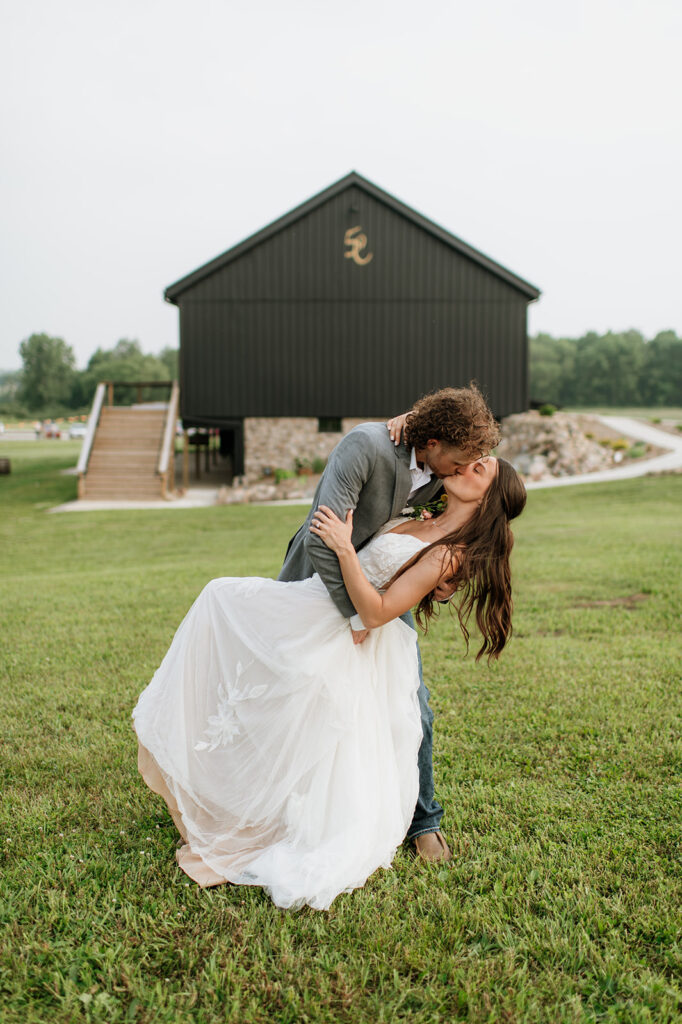 Bride and groom kissing outside of 5C Farms - Premier Indiana barn wedding venue