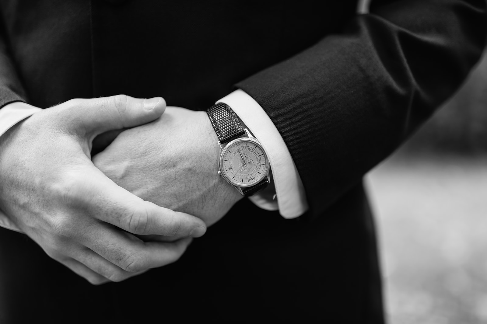 Black and white close-up of groom’s hands showing his classic wristwatch.
