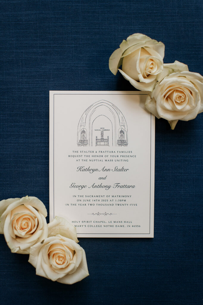 University of Notre Dame wedding invitation flatlay with romantic cream florals