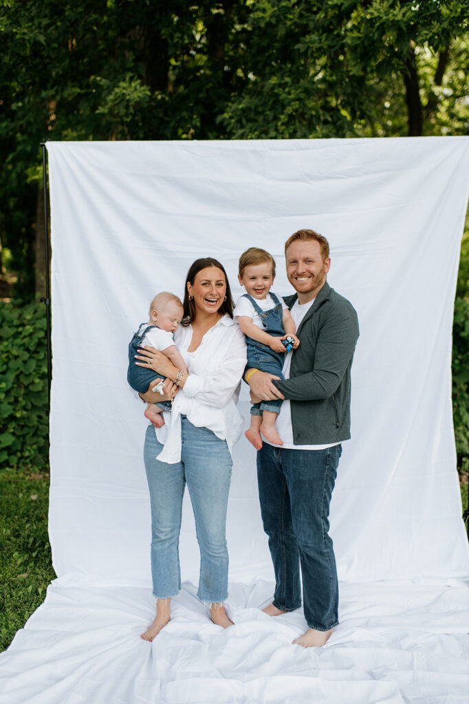 Family of four posing in front of a white sheet for their simple and relaxed Chicago family photography session