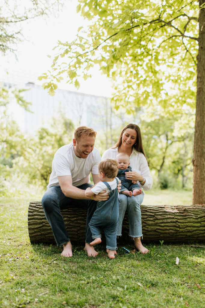 Family of four sitting on a log during their simple outdoor Chicago family photography session