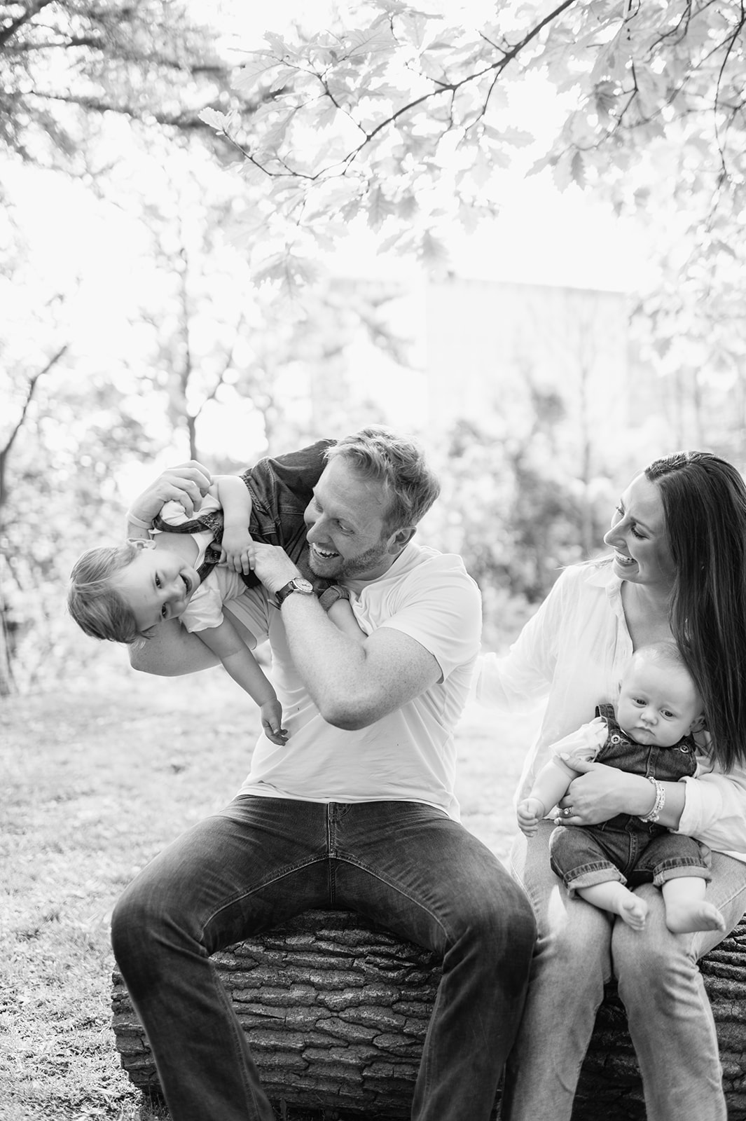 Black and white photo of a family of four being playful during their simple outdoor Chicago family photography session