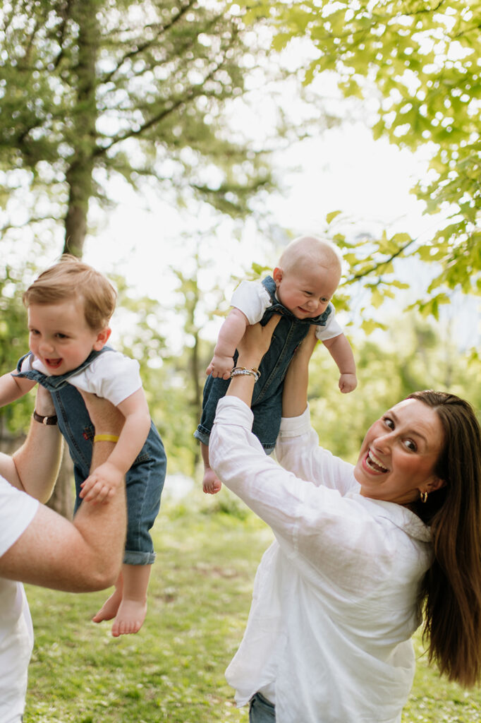 Mother and father holding their two young sons up in their air during their casual outdoor Chicago family photography session