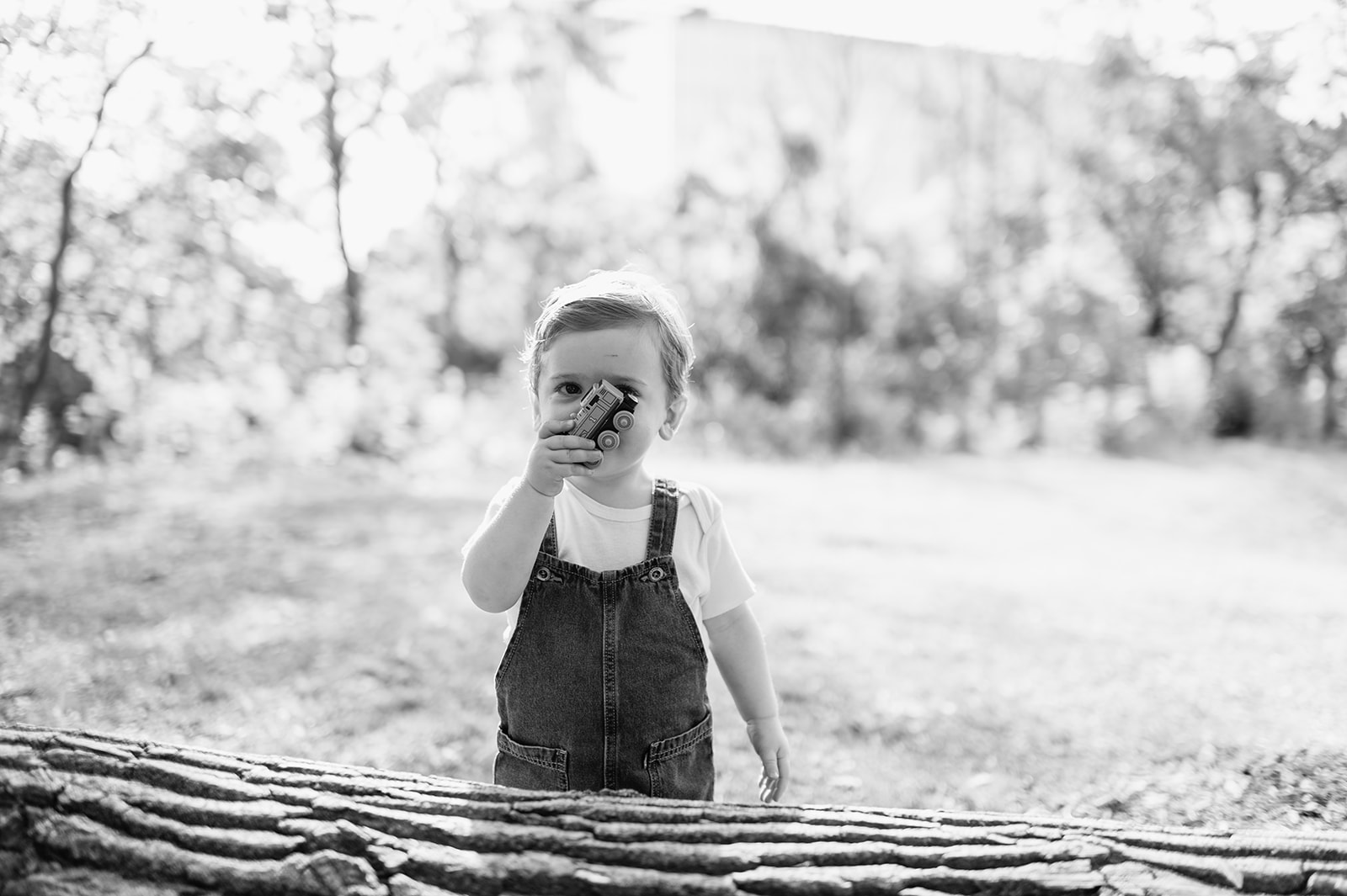 Black and white photo of a toddler holding a toy car outside during a simple Chicago family photography session