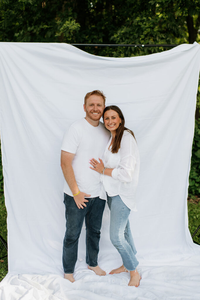 Couple posing in front of a simple white sheet backdrop for their Chicago family photography session