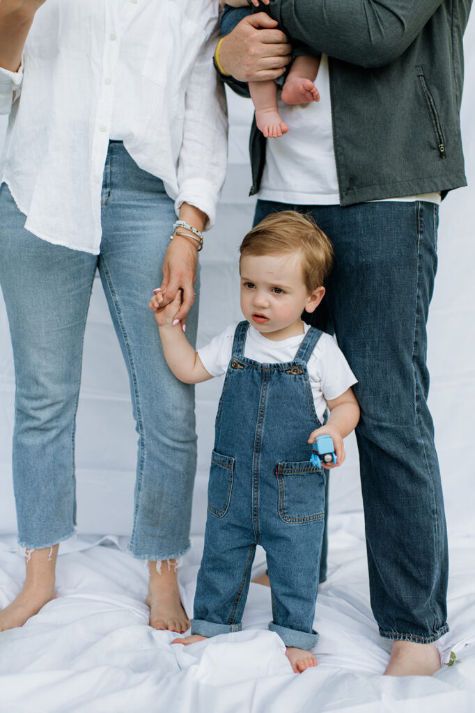Close up shot of a young boy holding his mothers hands during their simple outdoor Chicago family photography session