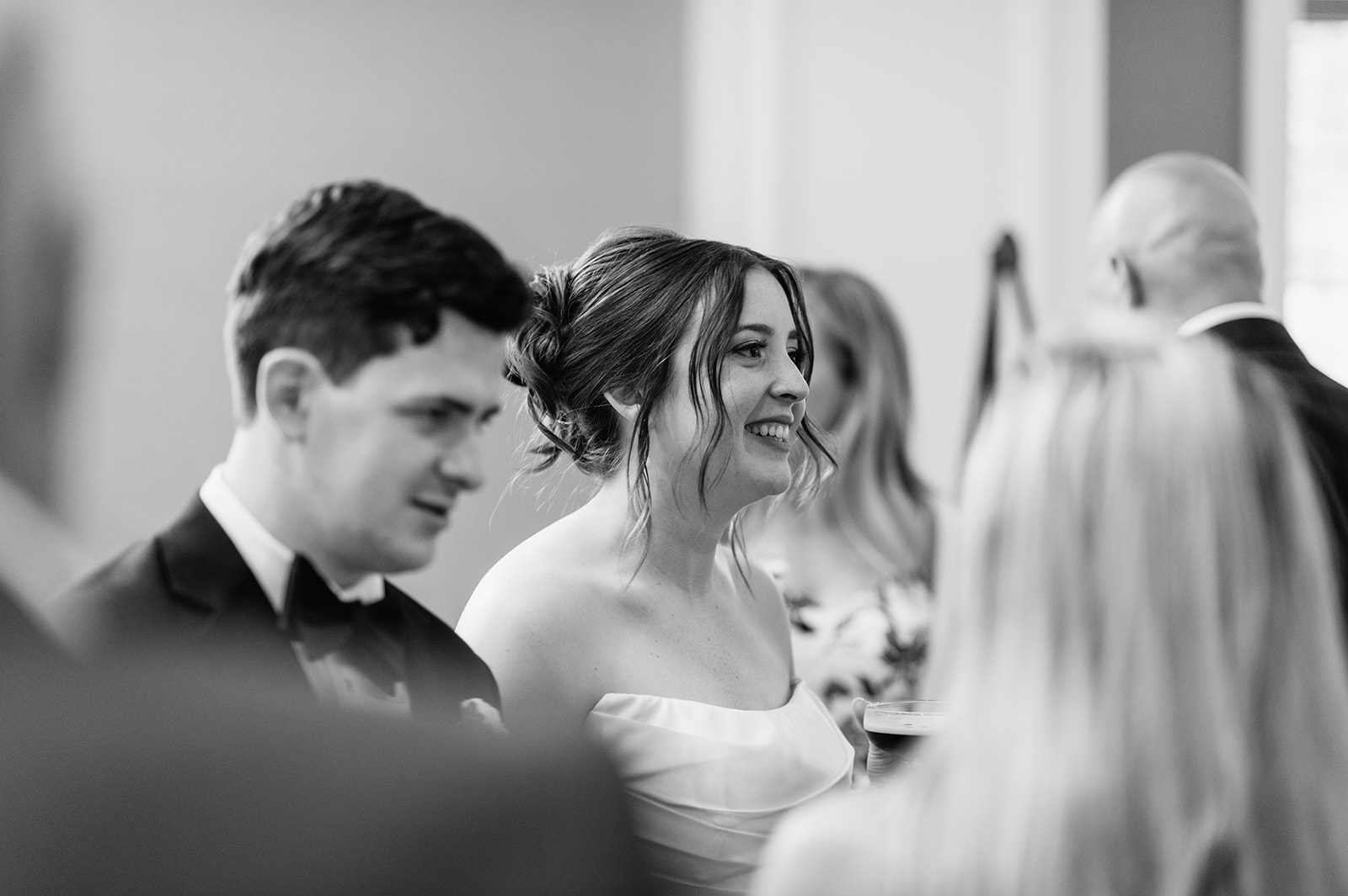 Black and white photo of a bride and groom mingling during cocktail hour