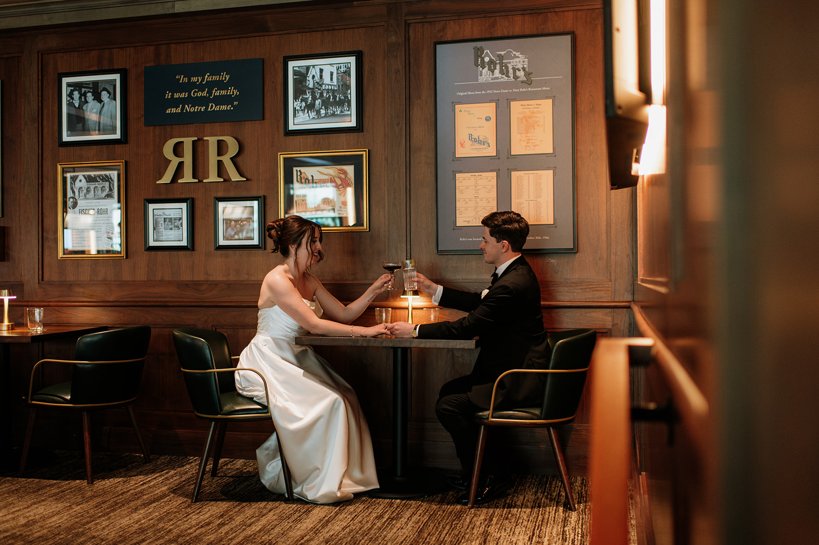 The couple shares a celebratory drink at Rohr’s restaurant inside the Morris Inn, seated at the table where they had their first date.