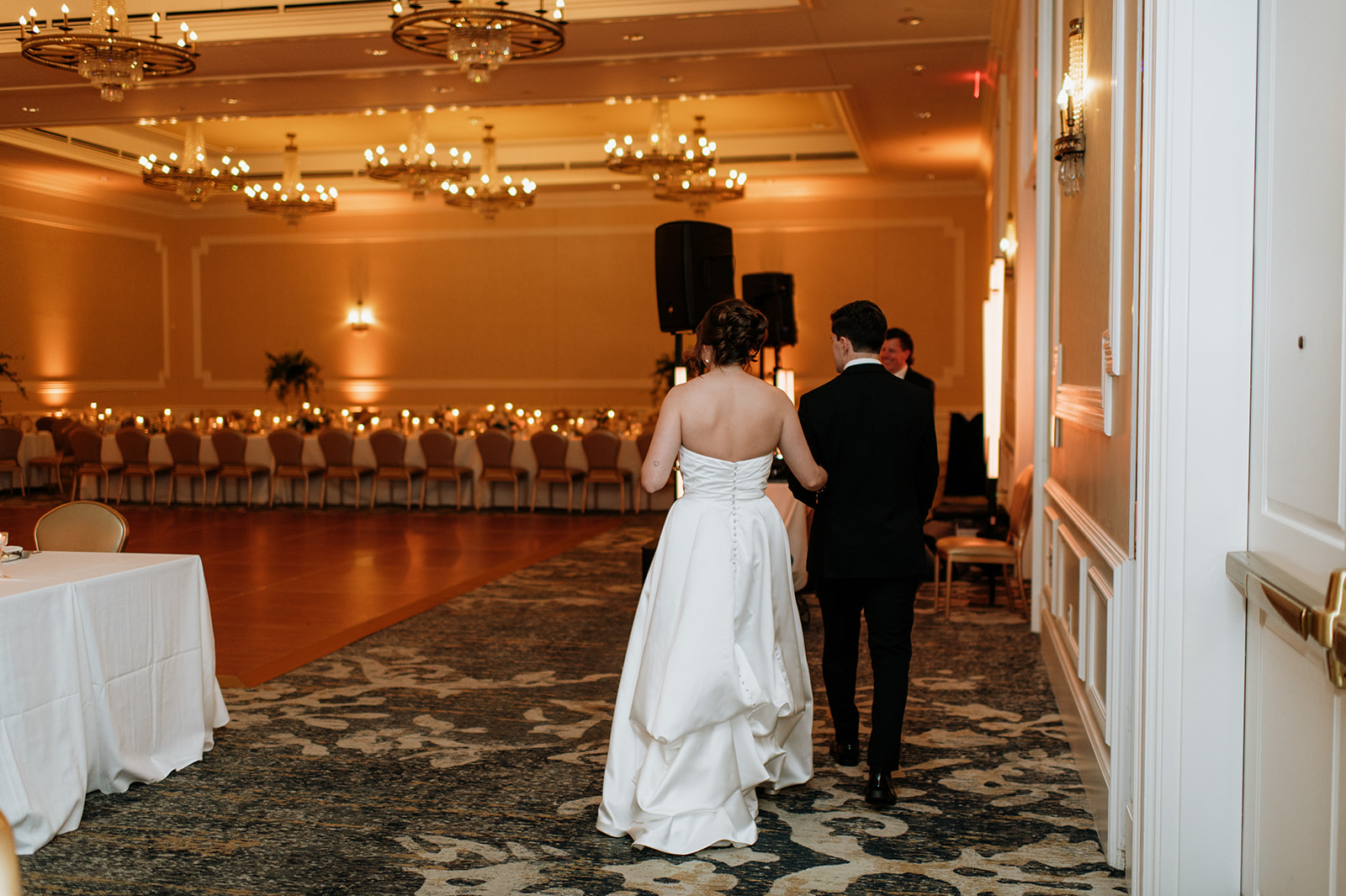Bride and groom walking into their wedding reception at Smith Ballroom at The Morris Inn for their wedding reception room reveal
