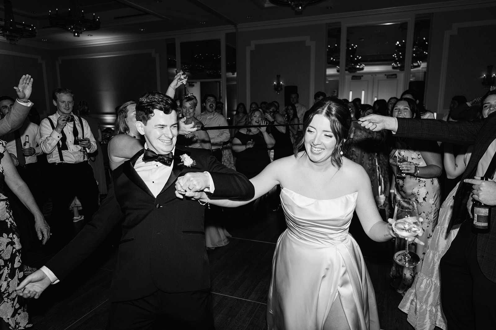 The bride and groom together aftera fun limbo game on the dance floor surrounded by cheering guests.