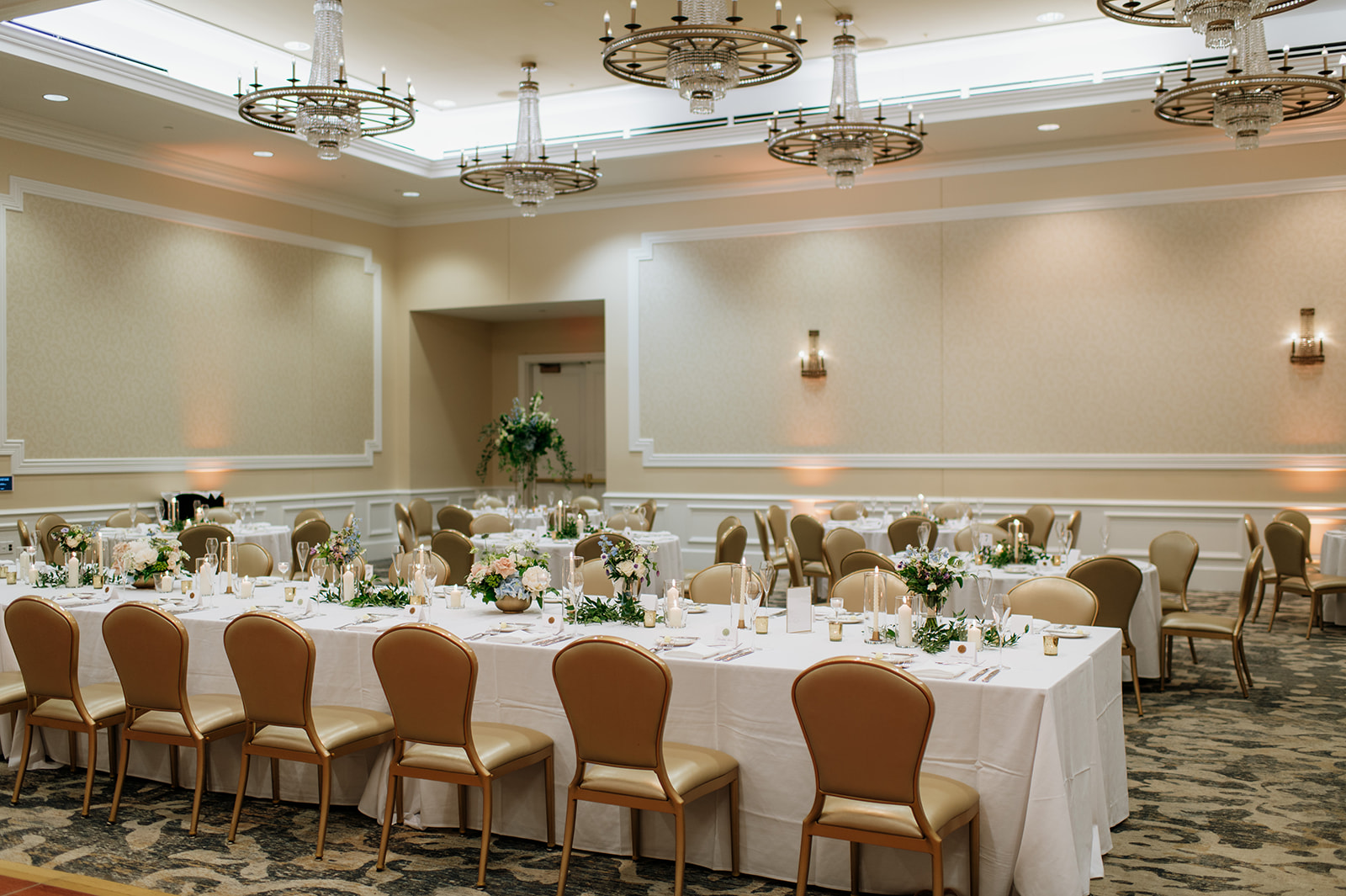 Elegant long banquet tables with greenery, pastel florals, and candles inside the Smith Ballroom at The Morris Inn.