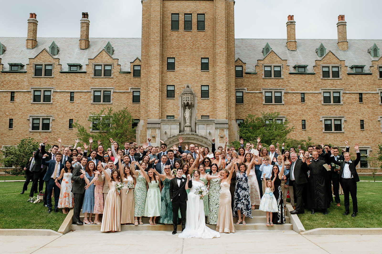Large group shot of a bride and groom with all of their guests in front of  The Holy Spirit Chapel in LeMans Hall at Saint Mary's College