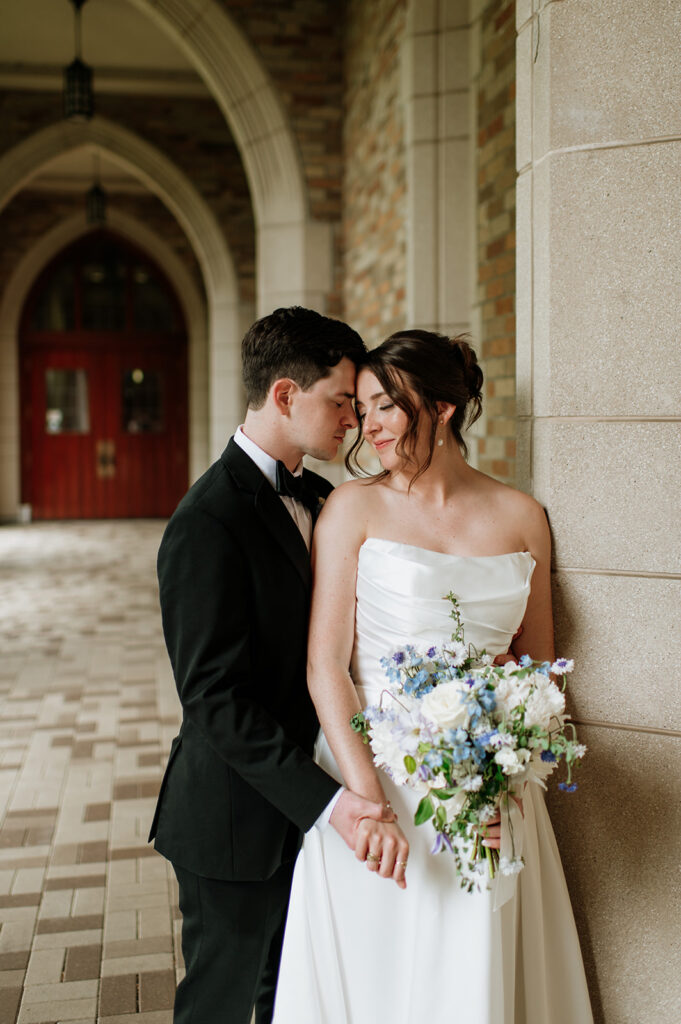 Bride and groom standing together in the arched walkways for their Notre Dame wedding portraits.