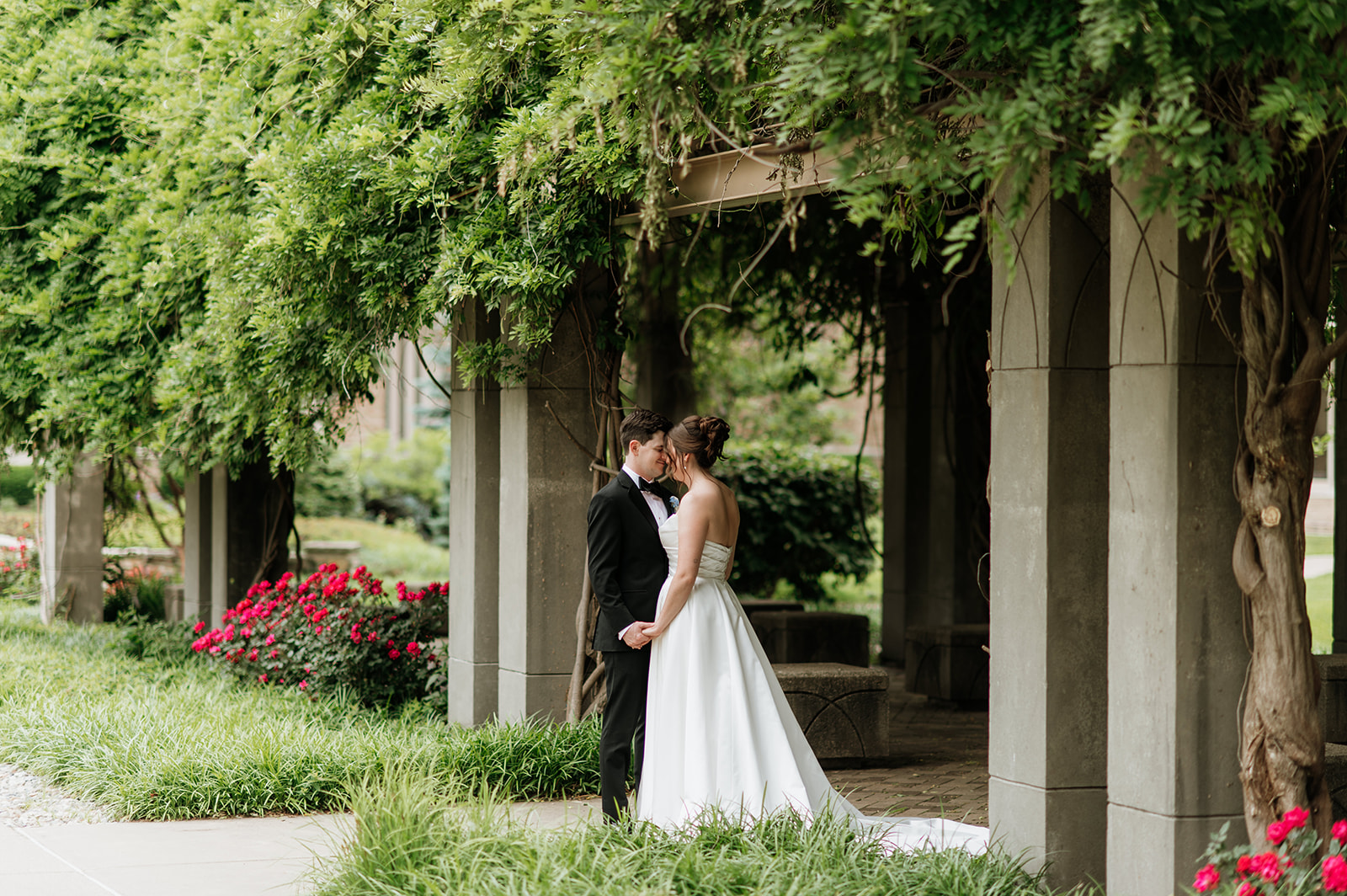 Bride and groom posing outdoors for their their Notre Dame wedding portraits.