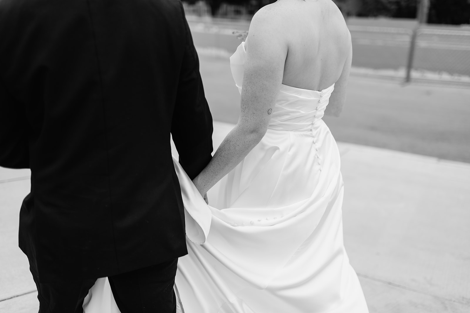 Close up black and white photo of a bride and groom walking on campus of Notre Dame