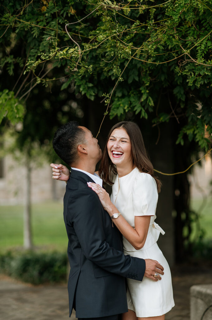 Candid engagement photo of a couple laughing